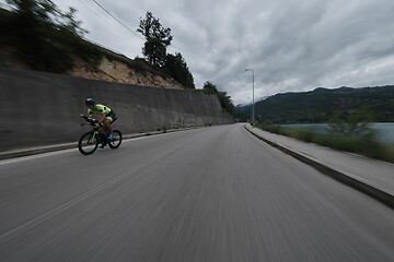 Image showing triathlon athlete riding a bike on morning training