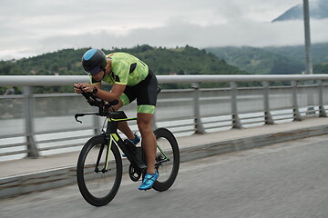 Image showing triathlon athlete riding a bike on morning training