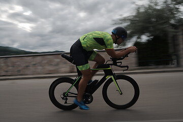 Image showing triathlon athlete riding a bike on morning training