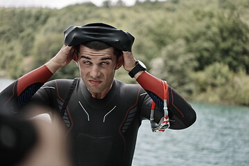 Image showing triathlon athlete getting ready for swimming training on lake