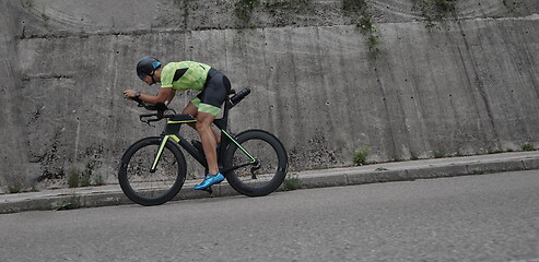 Image showing triathlon athlete riding a bike on morning training