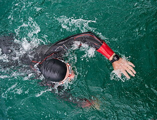 Image showing triathlon athlete swimming on lake wearing wetsuit