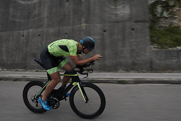 Image showing triathlon athlete riding a bike on morning training