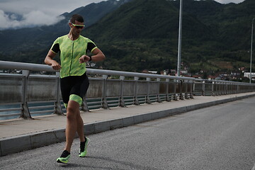 Image showing triathlon athlete running on street