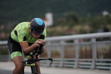 Image showing triathlon athlete riding a bike on morning training