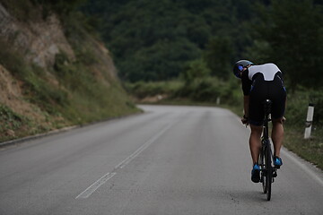 Image showing triathlon athlete riding a bike wearing black