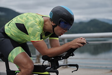 Image showing triathlon athlete riding a bike on morning training