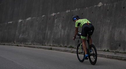 Image showing triathlon athlete riding a bike on morning training