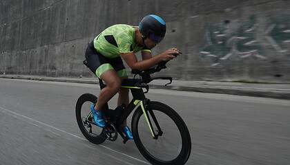 Image showing triathlon athlete riding a bike on morning training