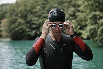 Image showing triathlon athlete getting ready for swimming training on lake