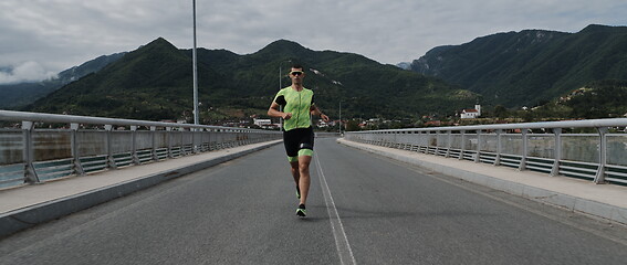 Image showing triathlon athlete running on street