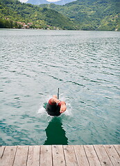 Image showing triathlon athlete jumping in water and starting with training