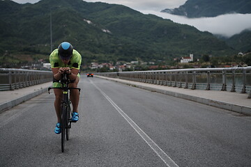 Image showing triathlon athlete riding a bike on morning training