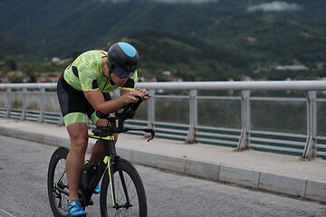 Image showing triathlon athlete riding a bike on morning training