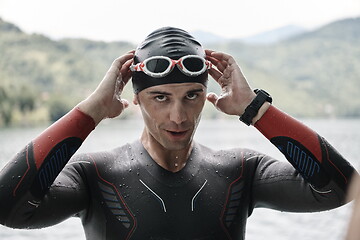 Image showing triathlon athlete getting ready for swimming training on lake