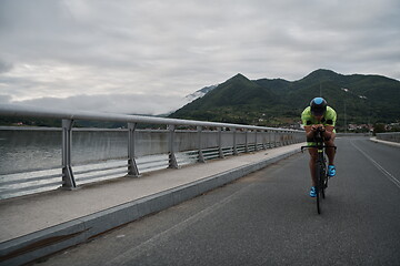 Image showing triathlon athlete riding a bike on morning training