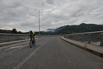 Image showing triathlon athlete riding a bike on morning training