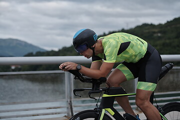 Image showing triathlon athlete riding a bike on morning training