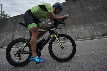 Image showing triathlon athlete riding a bike on morning training