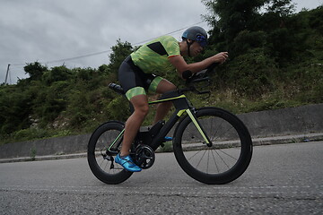 Image showing triathlon athlete riding a bike on morning training