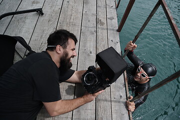 Image showing videographer taking action shot of triathlon swimming athlete