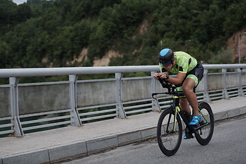 Image showing triathlon athlete riding a bike on morning training