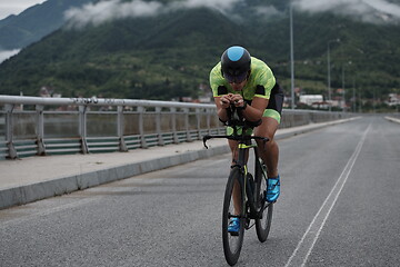 Image showing triathlon athlete riding a bike on morning training