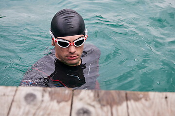 Image showing triathlete swimmer portrait wearing wetsuit on training