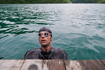 Image showing triathlete swimmer portrait wearing wetsuit on training