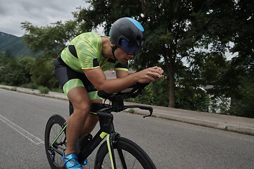 Image showing triathlon athlete riding a bike on morning training