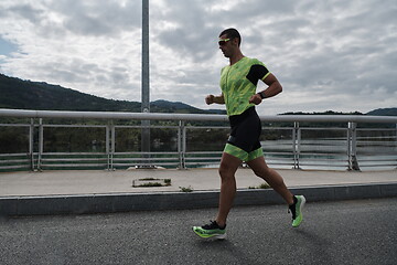 Image showing triathlon athlete running on street