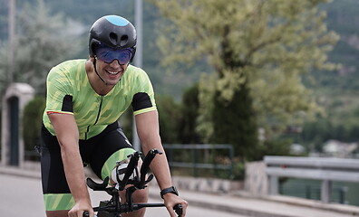 Image showing triathlon athlete riding a bike on morning training