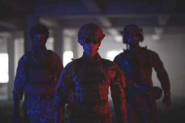 Image showing soldier squad team walking in urban environment colored lightis