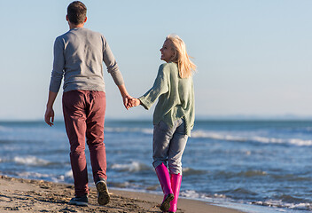 Image showing Loving young couple on a beach at autumn sunny day