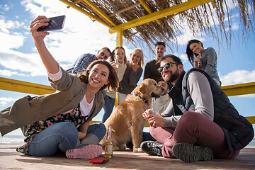 Image showing Group of friends having fun on autumn day at beach