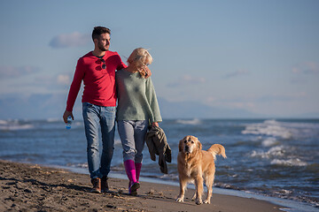 Image showing couple with dog having fun on beach on autmun day