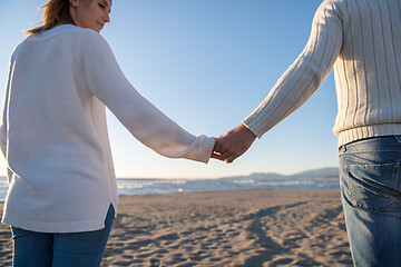 Image showing Loving young couple on a beach at autumn sunny day