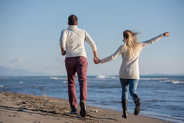 Image showing Loving young couple on a beach at autumn sunny day