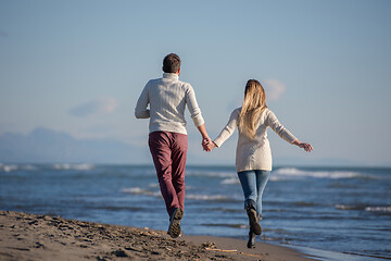 Image showing Loving young couple on a beach at autumn sunny day