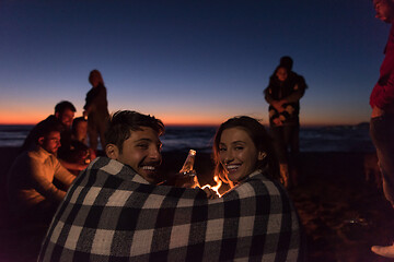 Image showing Couple enjoying with friends at sunset on the beach