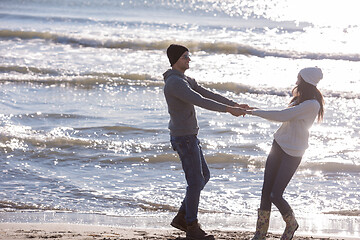 Image showing Loving young couple on a beach at autumn sunny day