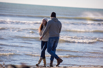 Image showing Loving young couple on a beach at autumn sunny day