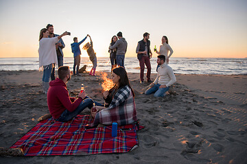 Image showing Couple enjoying with friends at sunset on the beach