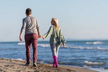 Image showing Loving young couple on a beach at autumn sunny day