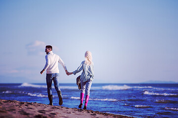 Image showing Loving young couple on a beach at autumn sunny day