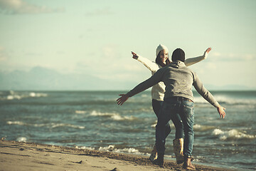 Image showing Loving young couple on a beach at autumn sunny day