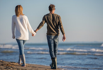 Image showing Loving young couple on a beach at autumn sunny day