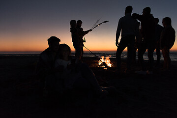 Image showing Couple enjoying bonfire with friends on beach