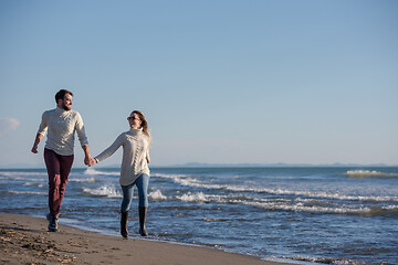 Image showing Loving young couple on a beach at autumn sunny day