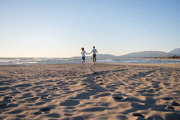 Image showing couple with dog having fun on beach on autmun day